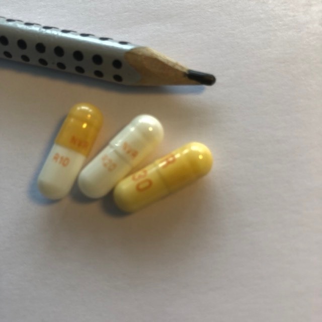 Trois gélules Ritalin marquées 10, 20 et 30 mg, photographiées à côté d’un crayon